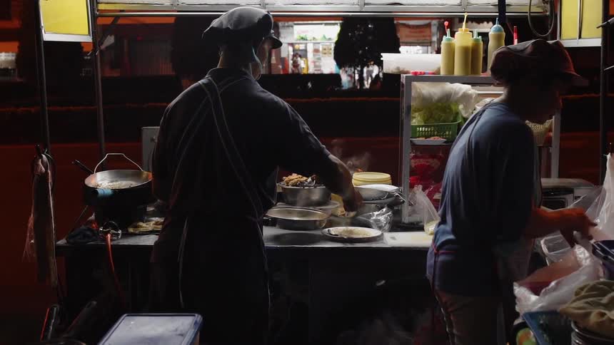 Two chefs work in a restaurant kitchen