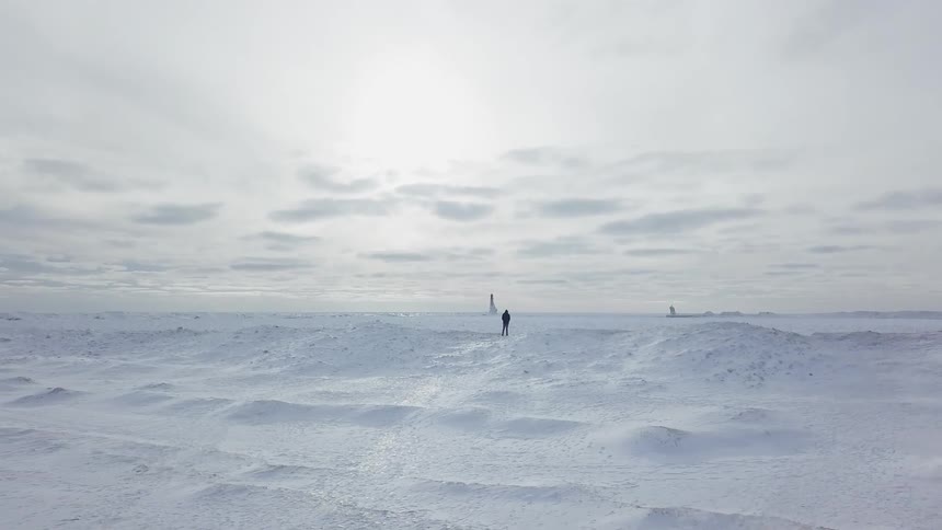 Man standing in desolate flat wilderness that is covered in snow
