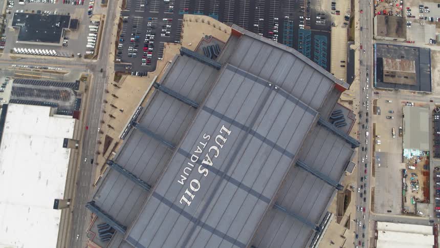 The large stadium is near the parking lot