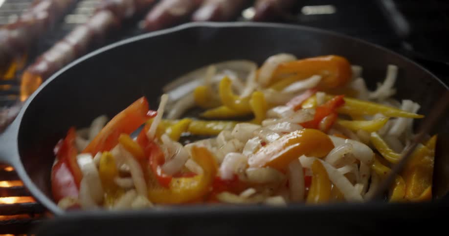 Person is stirring and grilling vegetables