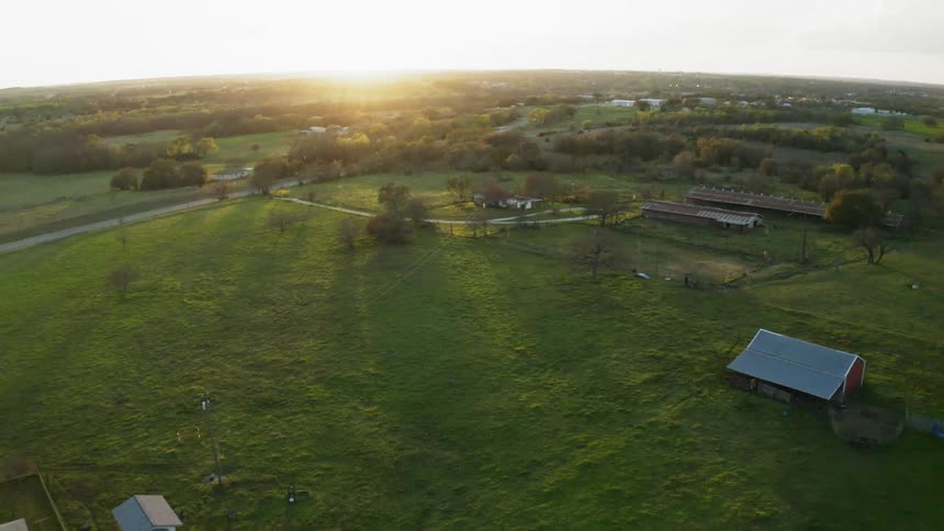 The sun sets over a rural landscape