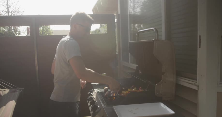 Man barbequeing on a hot summer day