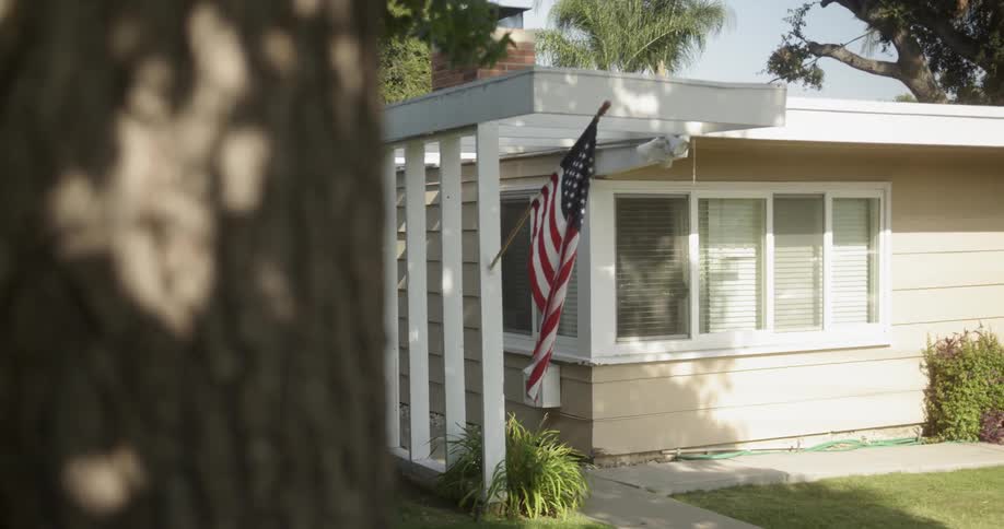 An american flag hangs from a house