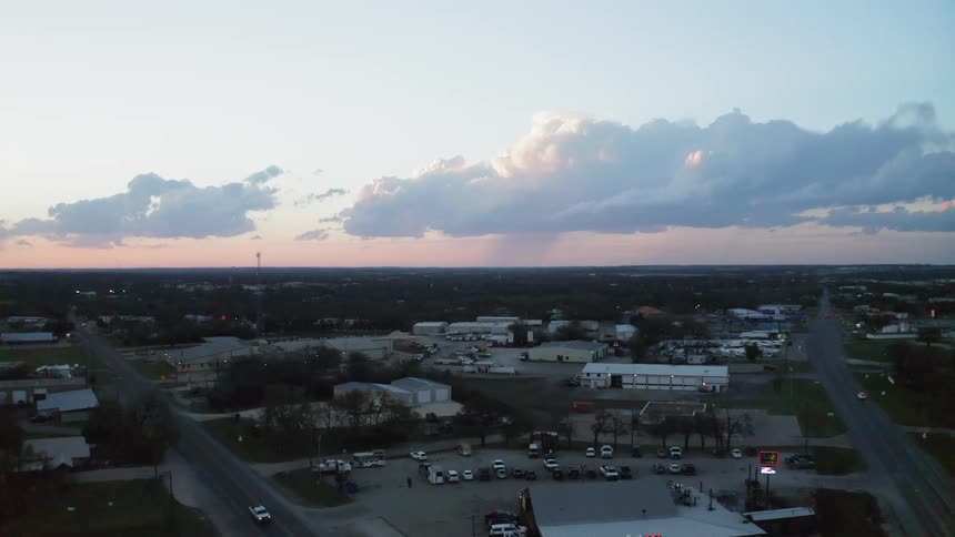Clouds float above a town at sunset