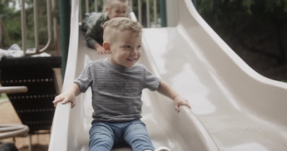 Two children play on a slide
