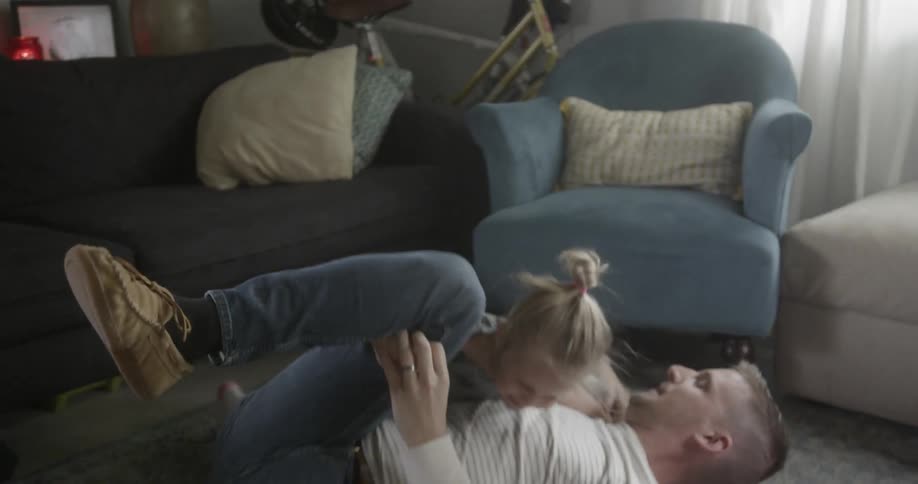 A child is having fun playing with her father