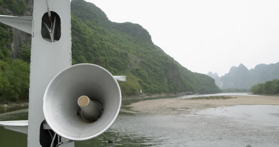 Water flows in a river and a megaphone is suspended on a piece of metal