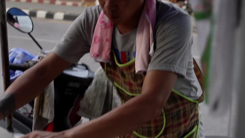 A man serves food at a food cart
