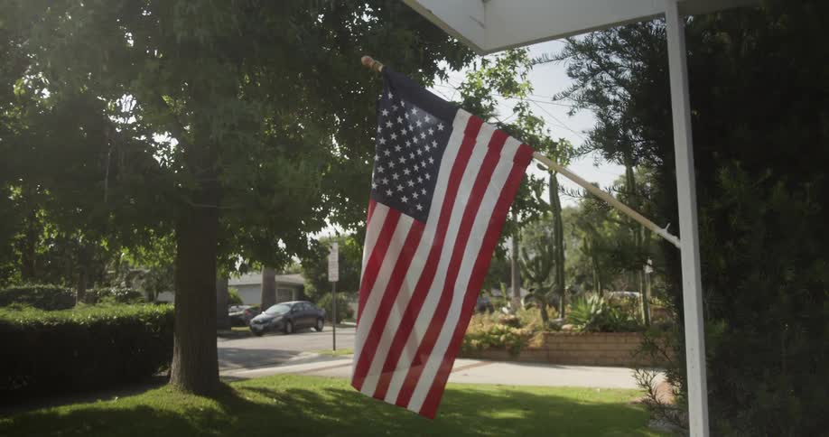 Flag hangs off a house waving in the wind
