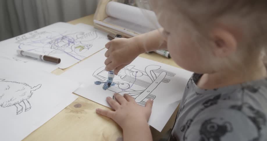 A child is coloring on the table