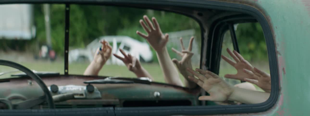 Hands reach into an abandoned car