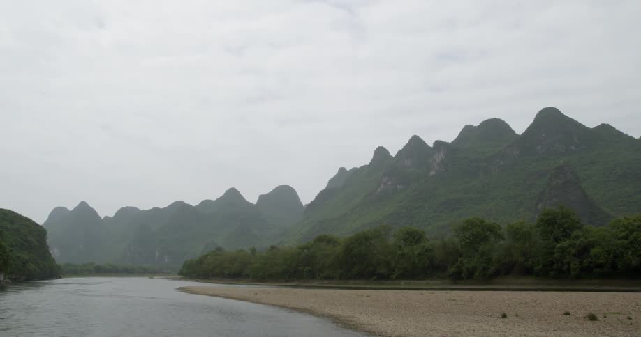 Mountains tower over the flowing river