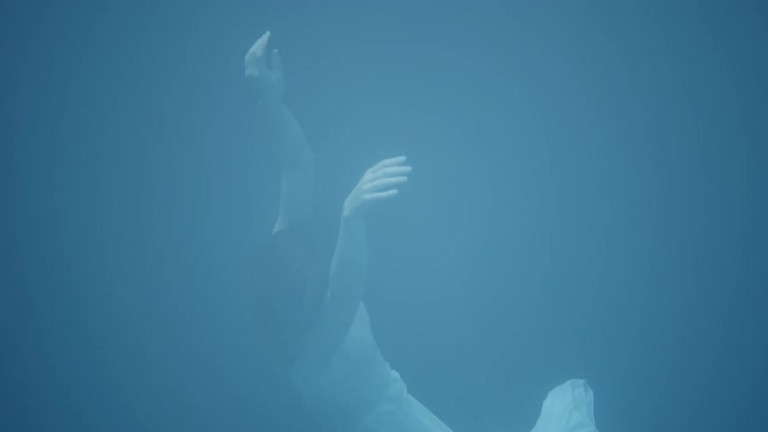 Woman wearing a white dress floats in a large pool of water