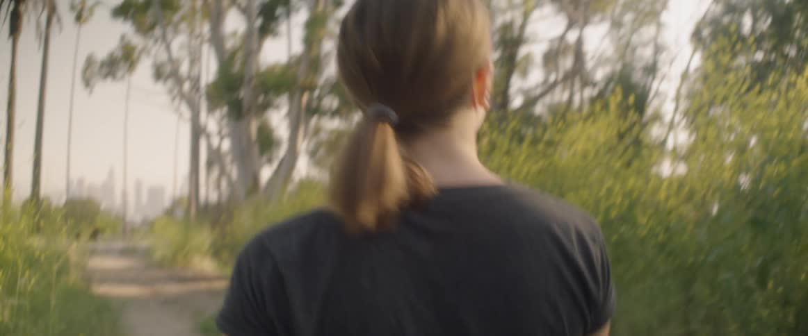 Woman is observing surroundings while walking on dirt path
