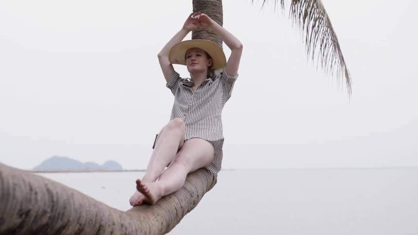 A woman rests on a tree branch