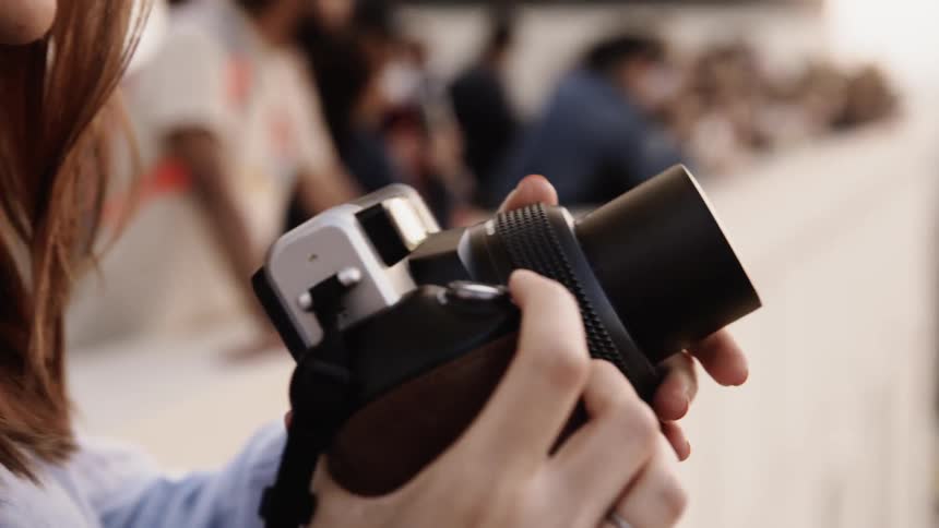 A woman is using a camera on a sunny day