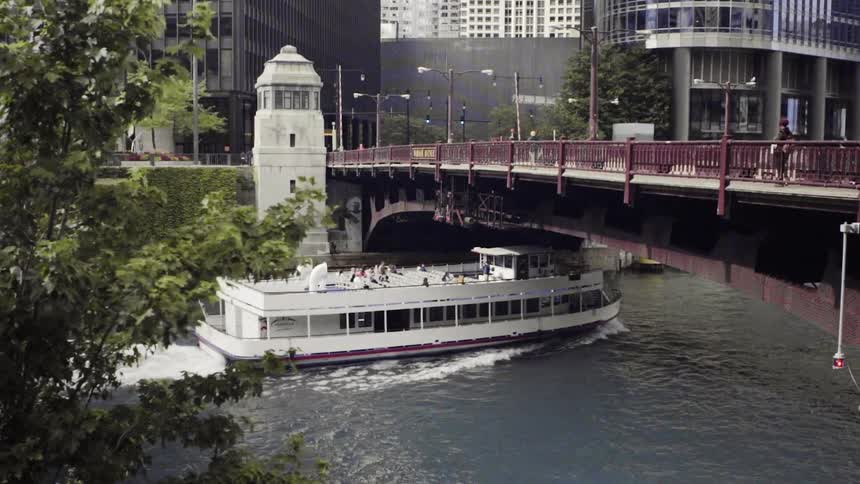 The boat sails under the bridge