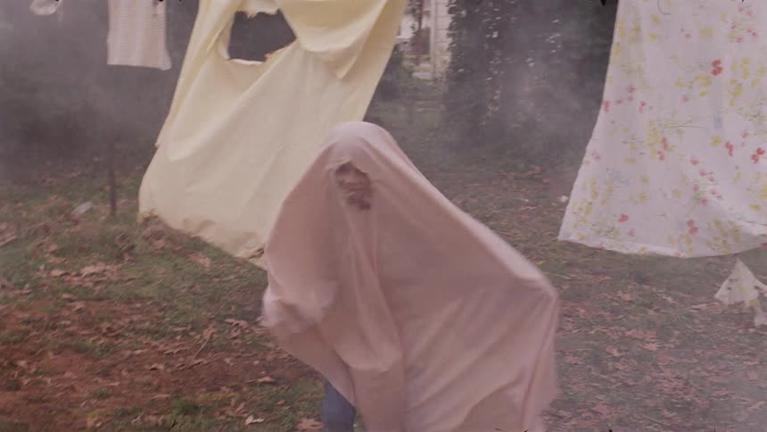 Young child wearing a sheet runs through the smoke