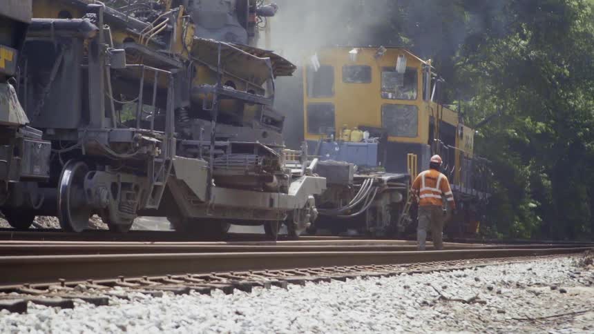 A man is following a train along on the tracks