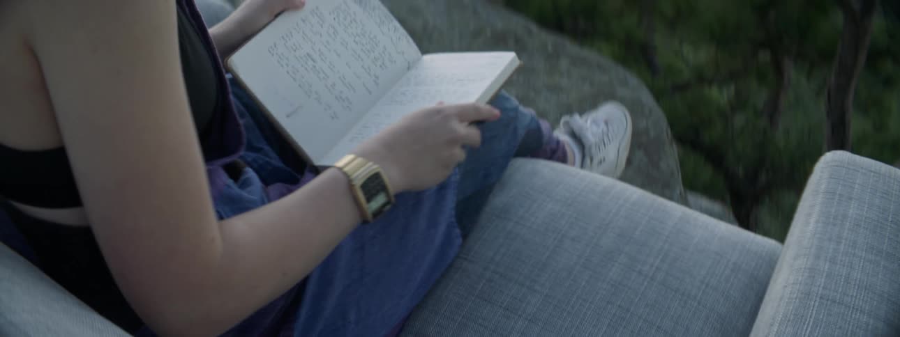 A woman picks the book up opening it