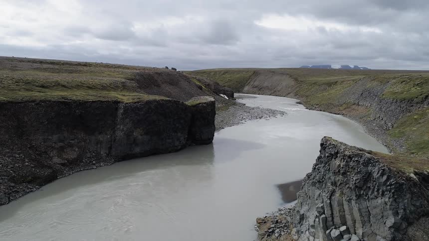 A river is wending through a canyon on a cloudy day