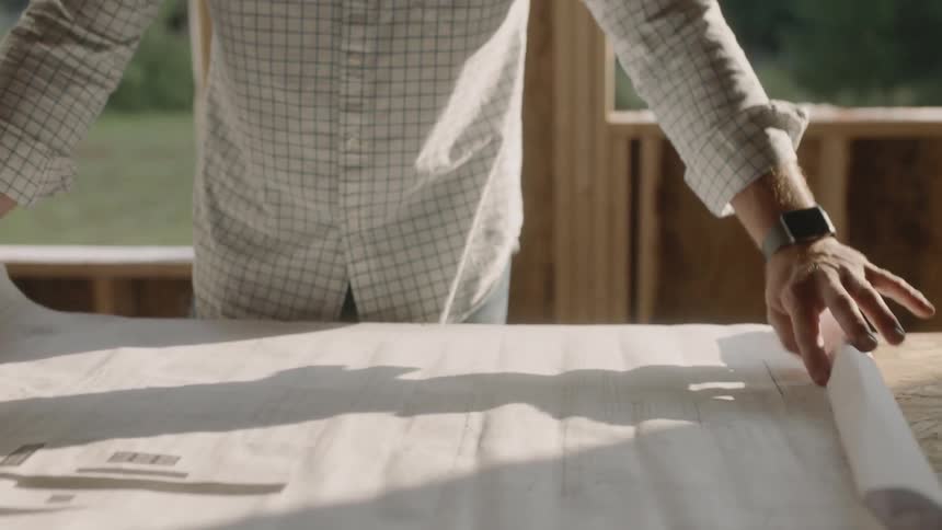 A man rolls out a blueprint