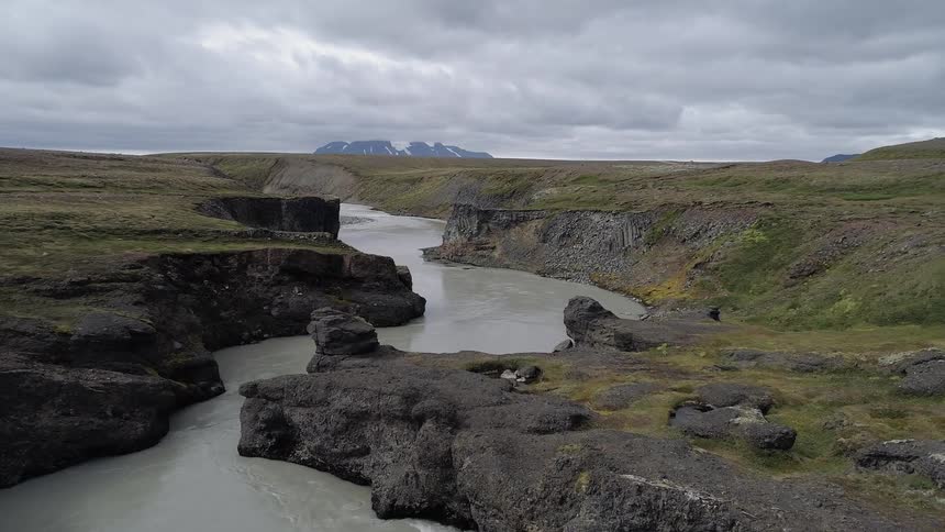 A river flows through a canyon on a cloudy day