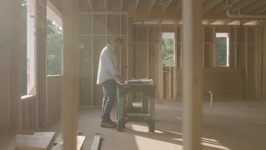 A man leans on a workbench
