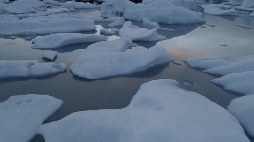 The large icebergs sit in the calm water