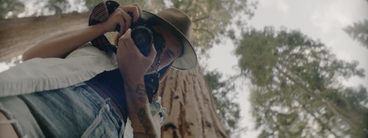 Man wearing a hat takes a photo with his camera