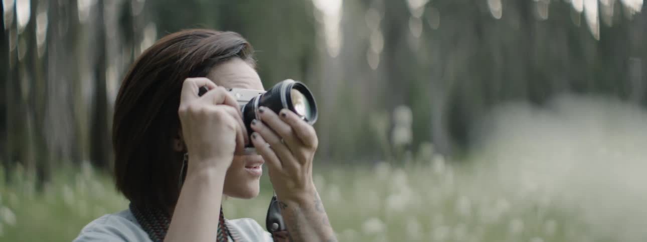 A woman is taking photographs of nature