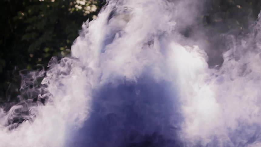The man stands still as the smoke covers him