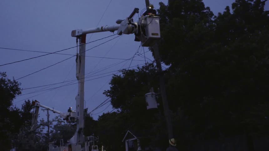 Workers fix a power line at night
