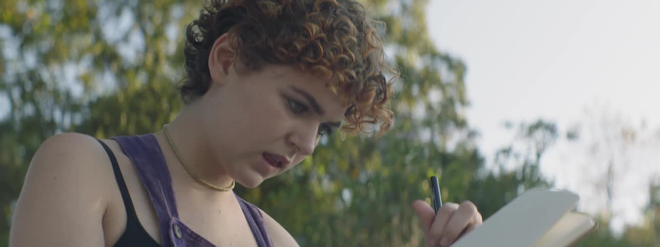 A woman writes outside