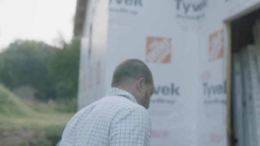 Man Looks At Blueprints For A Construction Site