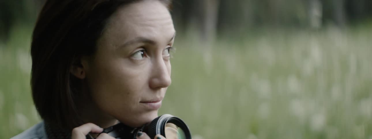 A woman takes photos in a forest