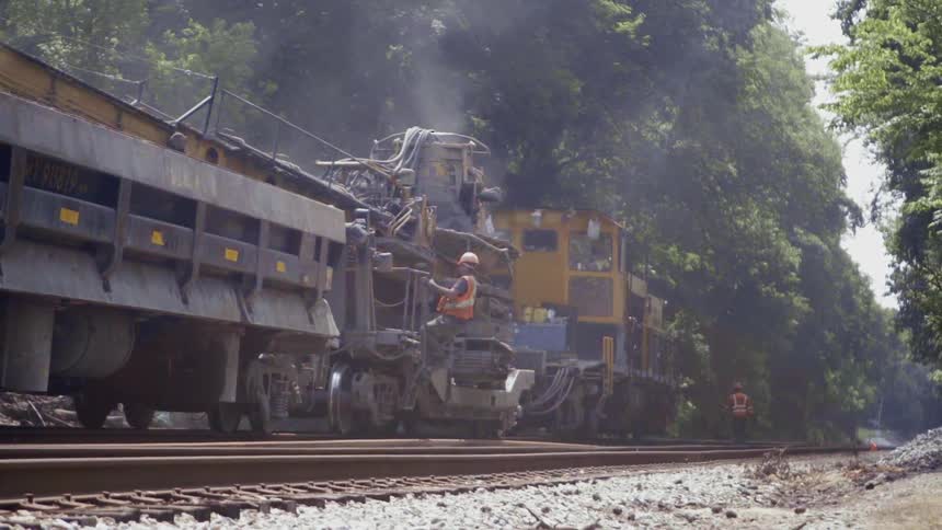 A worker climbs onto a parked train
