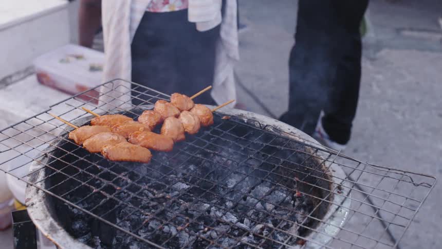 People cook on a grill outside