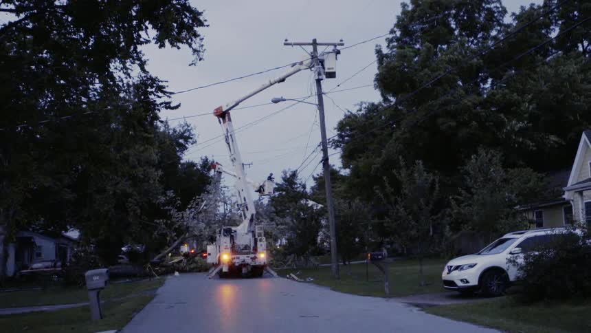 Crane is lifted high in the air at power lines