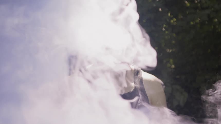 White smoke floats by the man