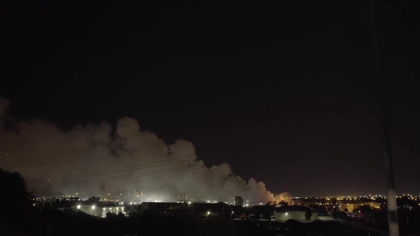 Smoke floats over a city at night