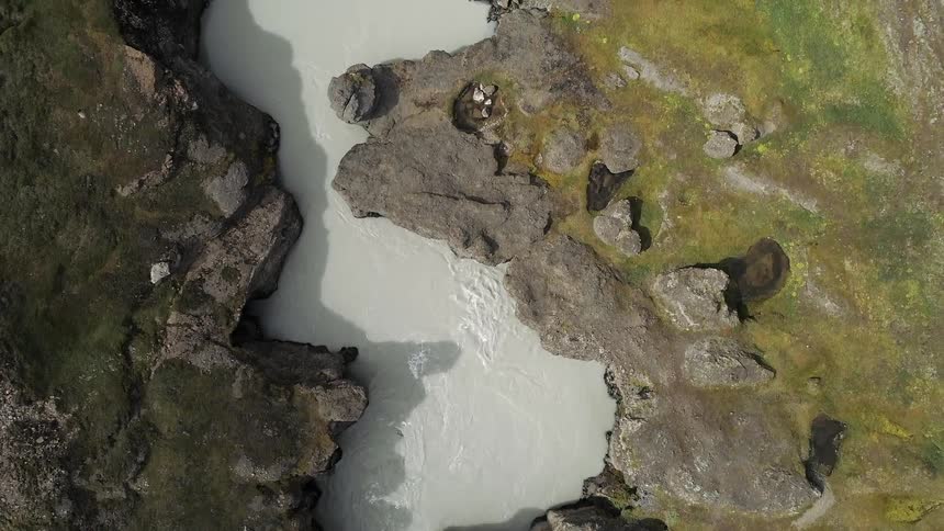 A muddy river flows in a canyon
