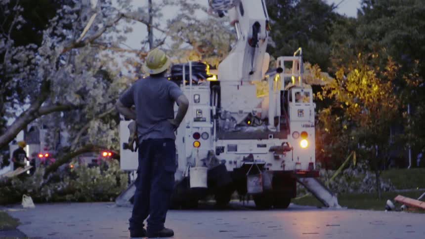 Electrical workers work to repair downed lines