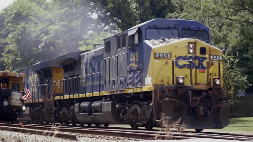 Train traveling on railroad tracks on sunny day