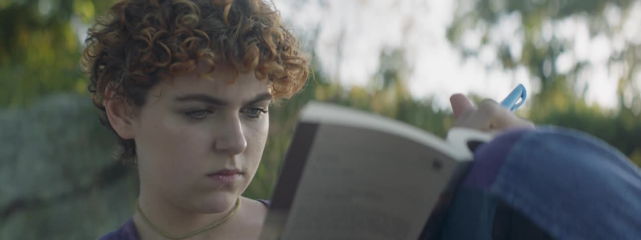 A woman is reading a book outside