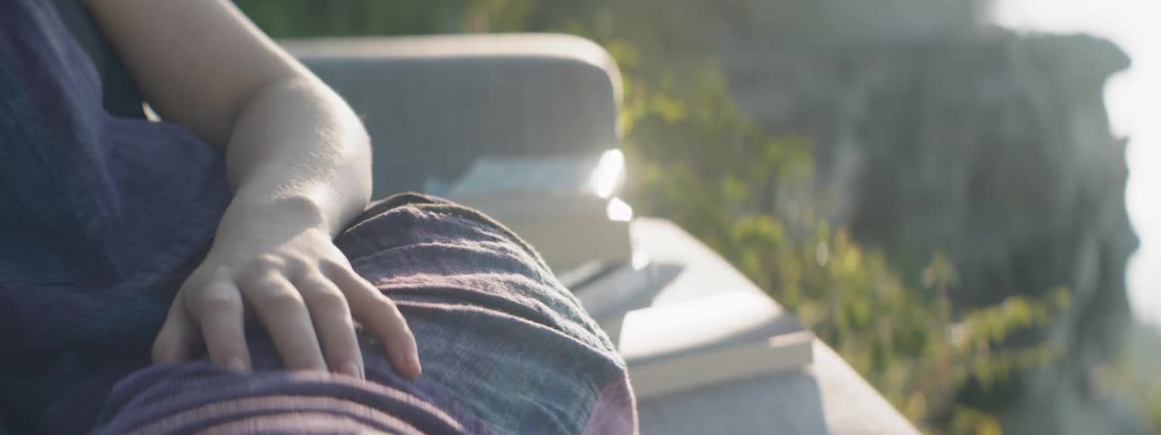 A woman sits on a sofa outside