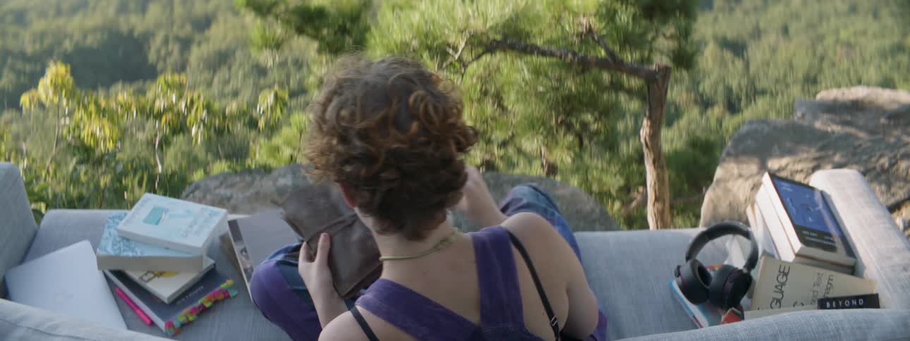 Woman wraps a string around a leather object while sitting outside