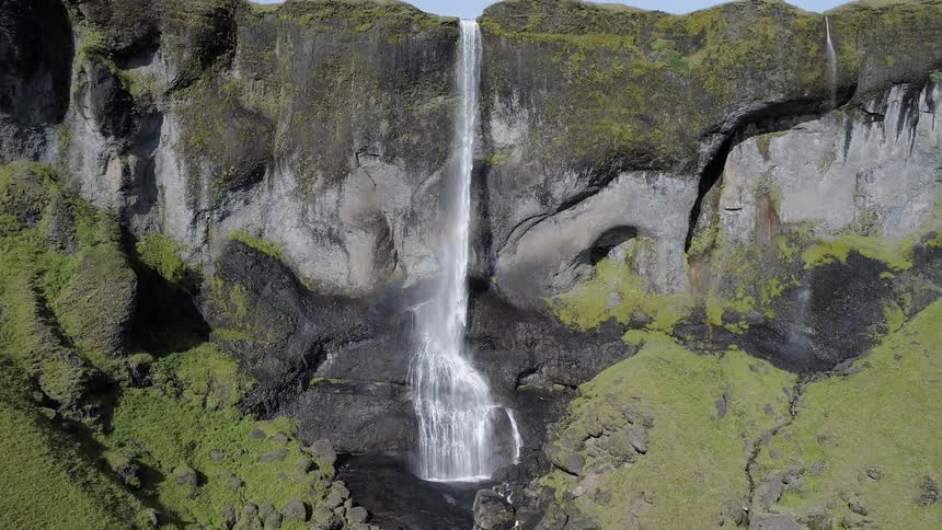 A waterfall flows over a cliff in the wilderness