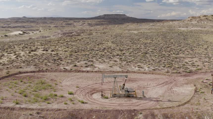 Machinery stands in a field as it digs for oil