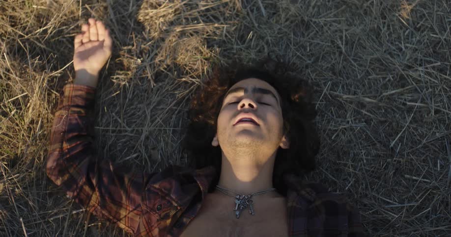 A man falls down laying in the hay